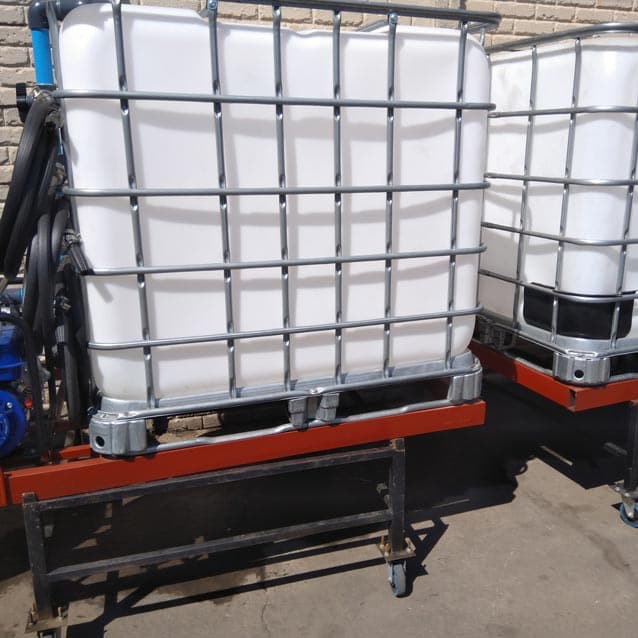 Two 1000 L flow bins on wheeled steel stands with a pump
