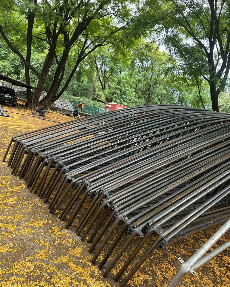 Steel tunnel arches stacked on the ground before assembly
