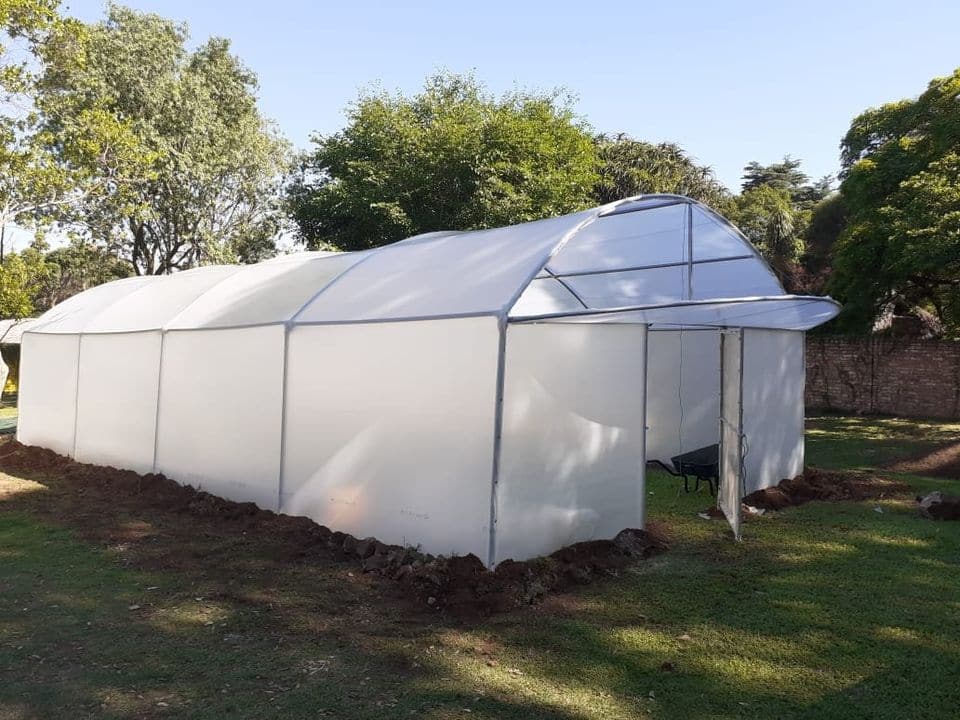 A small 6 m x 12 m hobby tunnel beside trees
